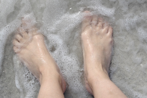 A person's feet soak in a freshly cleaned walk-in bathtub.