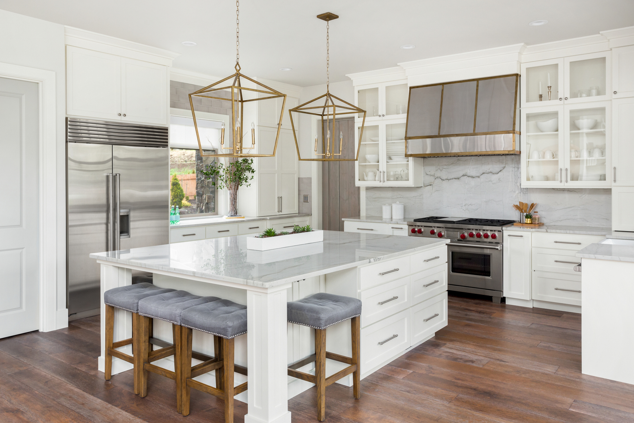 A lightly colored kitchen remodel with granite countertops and brightly painted cabinets.