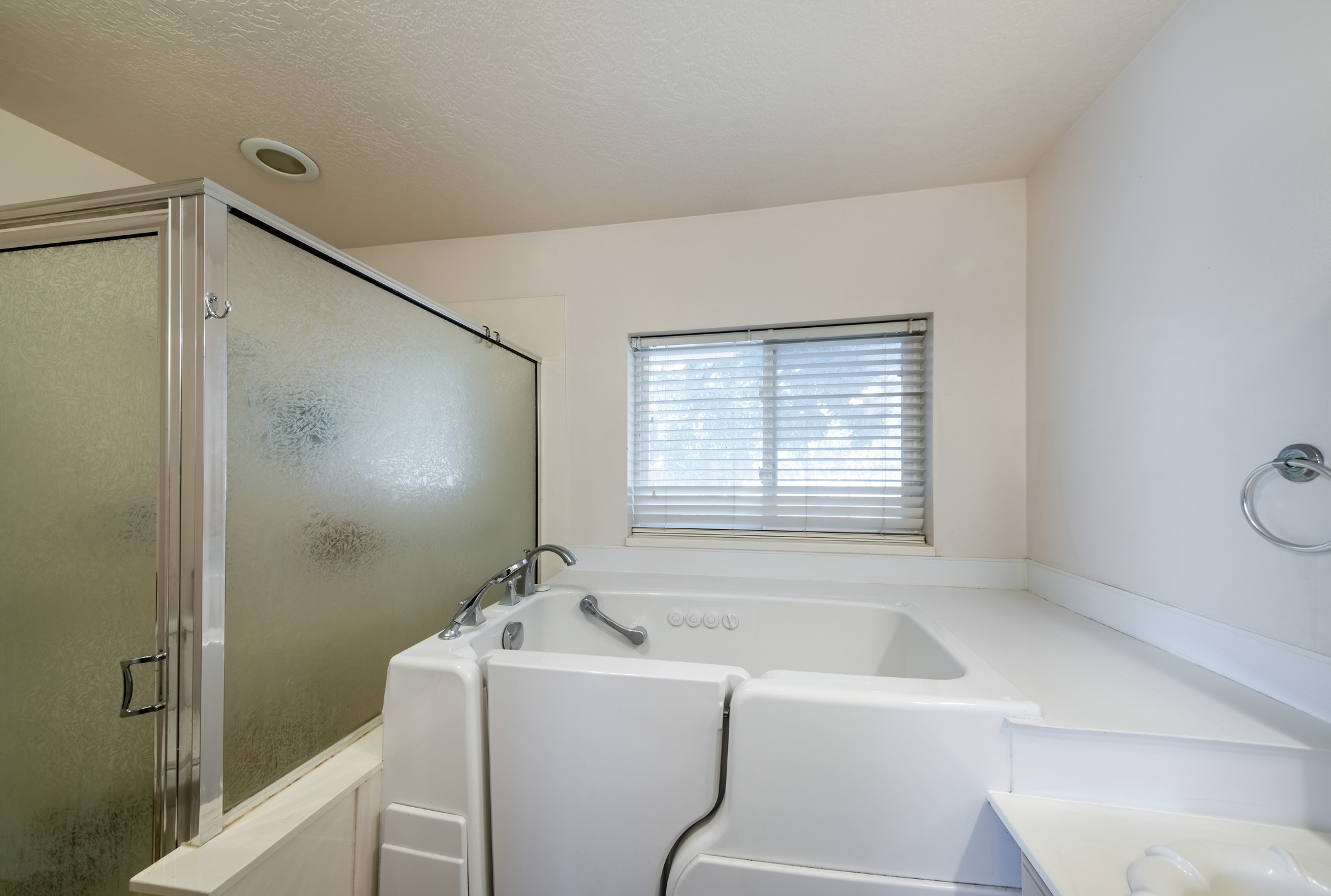 A walk-in bathtub showing the low-threshold door and grab bars designed for safe bathing for seniors.