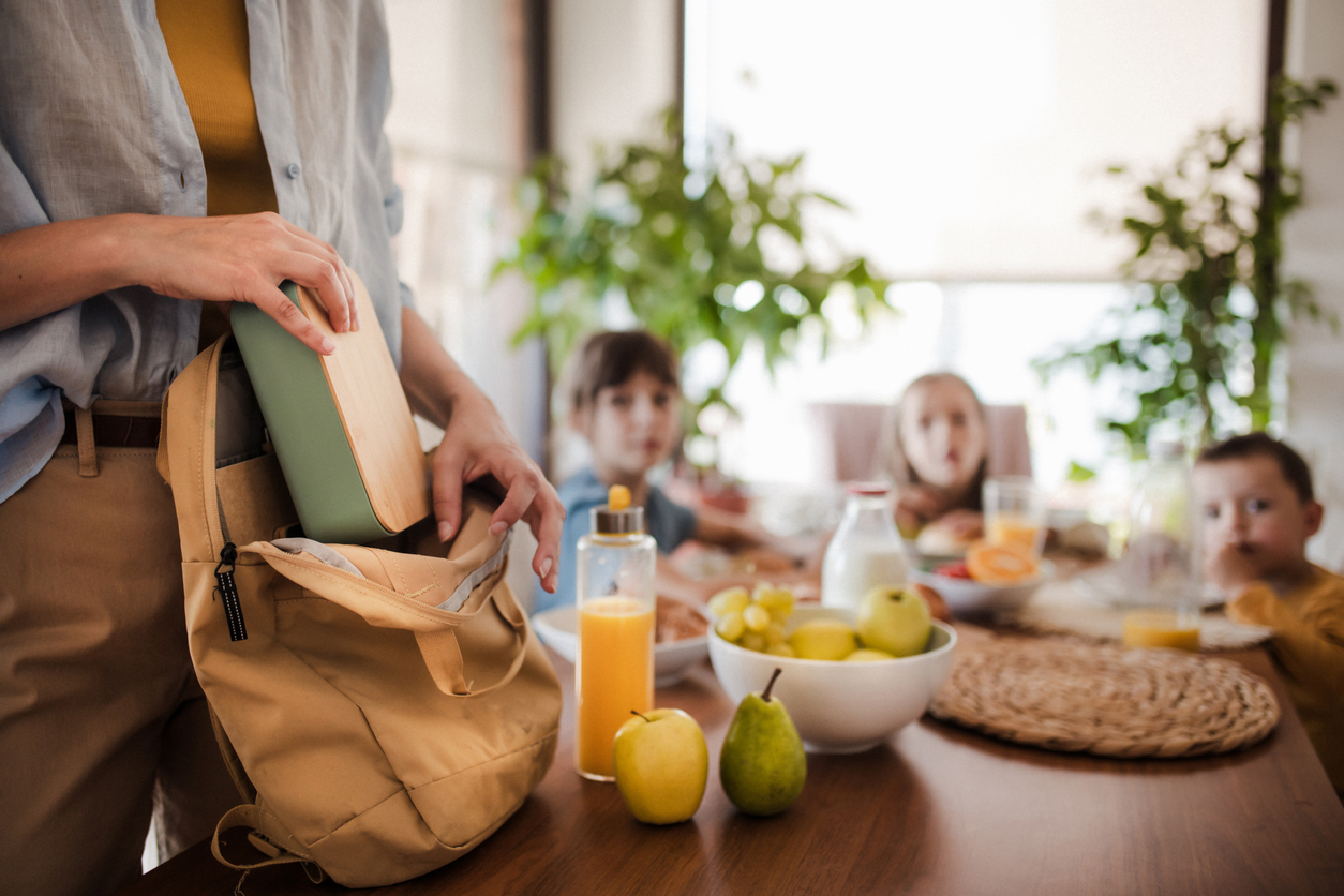 Mom packs a lunch in a bright, organized family kitchen.