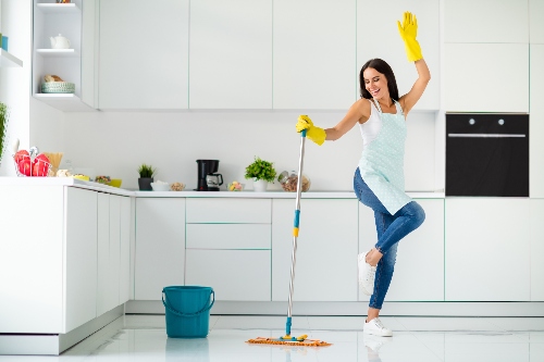 A model has fun while giving her kitchen a spring cleaning.