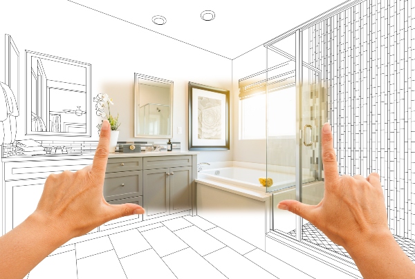 Hands frame a design spec of a bathroom remodel that is black and white around the edges and colored in the middle.